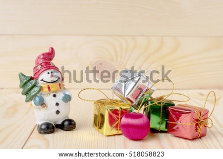 Snowman doll and Christmas decorations on wooden background with copy space.