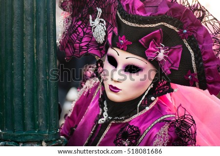 Beautiful violet mask at St. Mark square during the carnival of Venice.