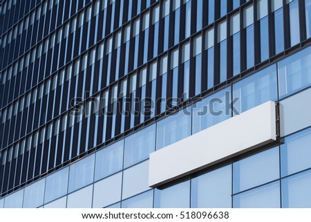 Horizontal side view of empty white signage on business skyscraper with modern architecture and glass windows