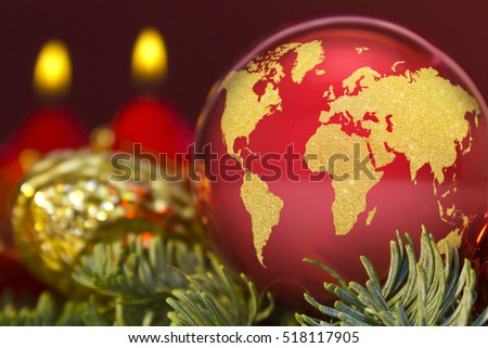 A glossy red bauble with the golden shape of the world.(series)
