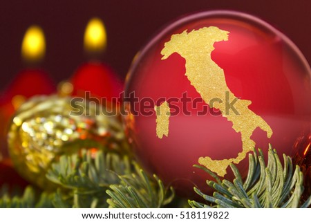 A glossy red bauble with the golden shape of Italy.(series)