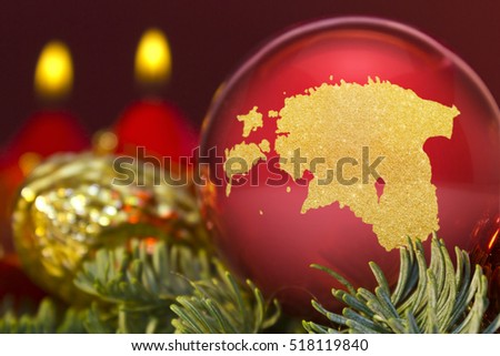 A glossy red bauble with the golden shape of Estonia.(series)