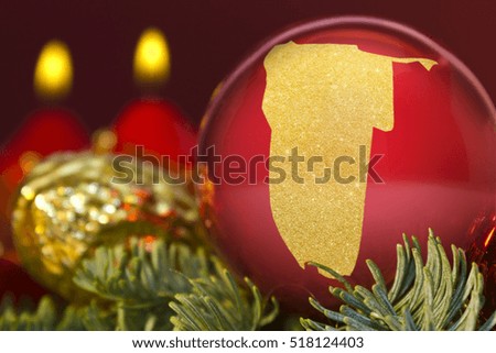 A glossy red bauble with the golden shape of Namibia.(series)