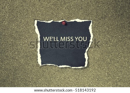We'll Miss You written on a torn black paper note pinned on a cork board. sticky note