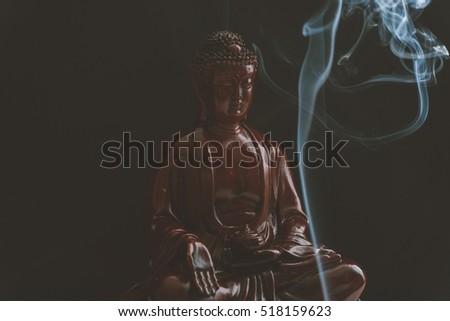 Decorative Buddha statue, Buddha in the background of incense, Shakyamuni attained enlightenment. The symbol of Buddhism. Film texture and shallow focus