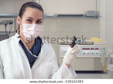 Female scientists with black mouse in research facility. focus on mouse and left eye of the scientist. This image is toned.