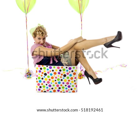 Woman in a box acting like a birthday surprise present image isolated on white background