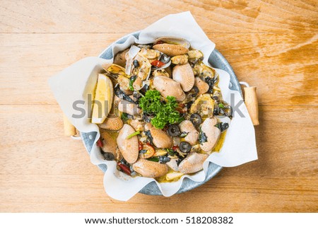 Fried clams with white wine in pan on wooden table - Processing Warm white balance