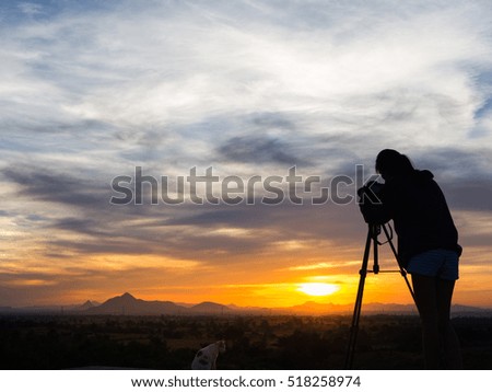 Silhouette of woman shooting with camera at sunset,Cat