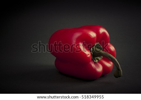 Red pepper isolated on dark background. Still-life picture taken in studio with light-box.