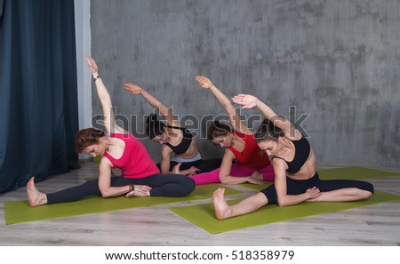 Group women doing exercise in yoga class. Group sportive woman in a gym training.