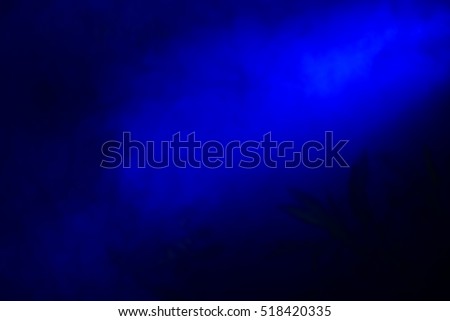 Blue colored smoke in the dark, dark background