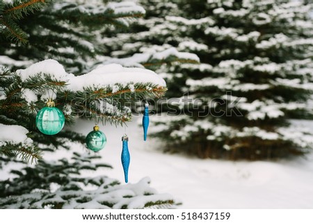 Decorations on the Christmas tree outdoors in a forest. Celebrating the New Year and holidays.