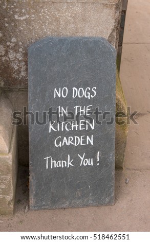 "No Dogs in the Kitchen Garden, Thank You !" Sign Hand Written on a Slate Tile at its Entrance in Rural Somerset, England, UK
