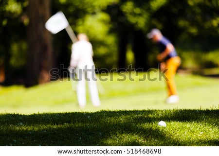 golf players on the course, note shallow depth of field