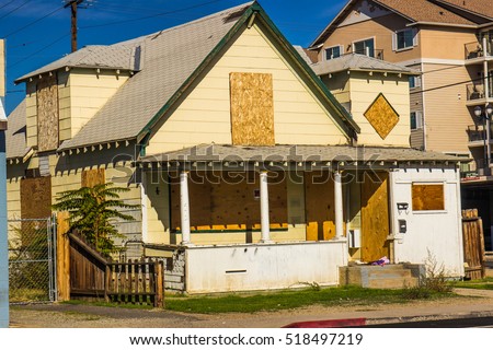Old Abandoned Home With Boarded Up Windows & Door Royalty-Free Stock Photo #518497219