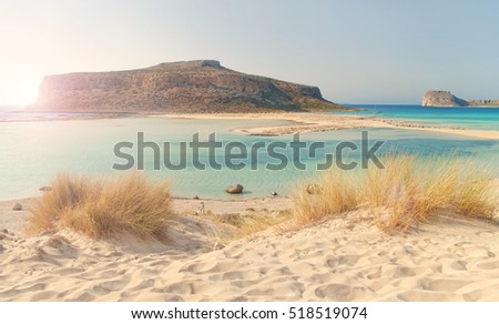 beautiful cross-processed image of Balos Bay at sunset with dry grass and soft sand at foreground, Chania, Crete, Greece Royalty-Free Stock Photo #518519074