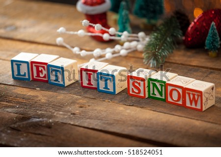 Let It Snow Written With Toy Blocks On Christmas Card Background With Copy Space.