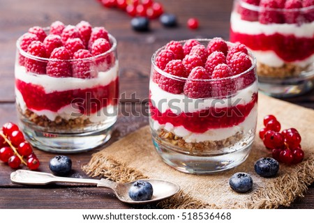 Raspberry dessert, cheesecake, trifle, mouse in a glass on a wooden background. Royalty-Free Stock Photo #518536468