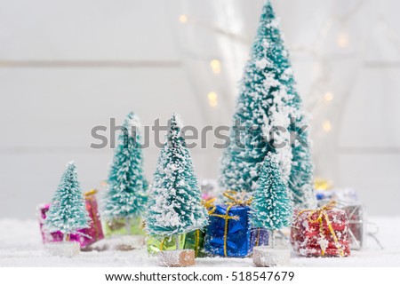 Artificial christmas trees with snow and gift boxes for background with copy space - shallow depth of field