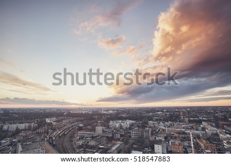 beautiful cityscape, sunset on the roof of the house, blue sky and clouds at sunset, view of the city from above