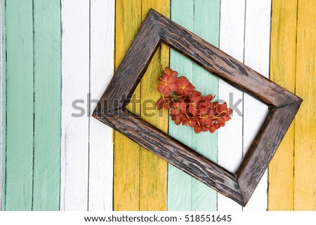 Background with fresh flowers in old frame on the old wooden background. Selective focus. Place for text.