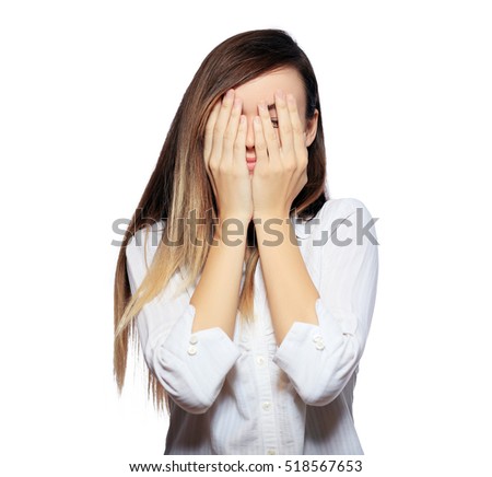 young brunette female hide her face in her hands, isolated on white