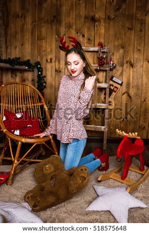 Beautiful girl sits on a background of Christmas decorations with a teddybear. Eco style. Christmas and New Year concept