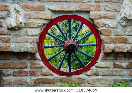 Vintage Wheel Red of the Wagon in the Wall Made of Bricks as Decoration