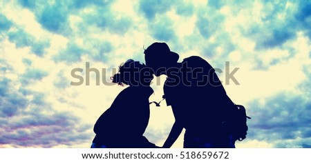 Couple kissing with a sky background.