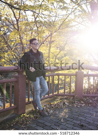 a man relaxing with a beautiful Japan ,  Nikko autumn tree . focus on the model .