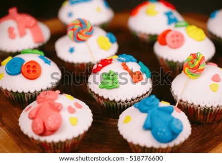 Baby cupcakes on the wooden background.