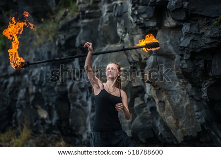 Girl in a black suit with flaming torches. fire