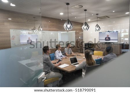 start up business people group attending videoconference call with senior investitior at modern office Royalty-Free Stock Photo #518790091