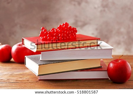 Pile of books and viburnum berries on wooden table