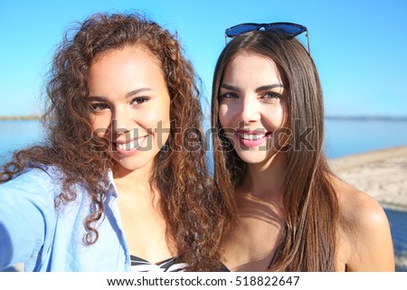 Beautiful girls taking selfie on beach