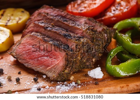 Juicy steak and grilled vegetables with spices Royalty-Free Stock Photo #518831080