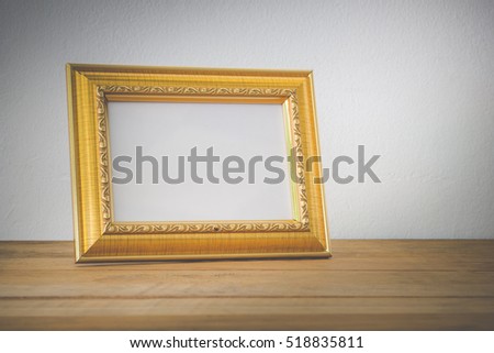 Gold photo frame on wooden 