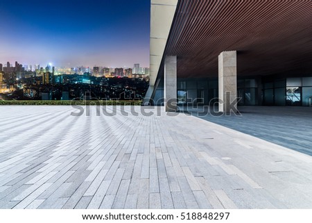 skyline and buildings with empty concrete square floor at night