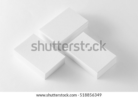 Mockup of three business cards stacks at white textured background.