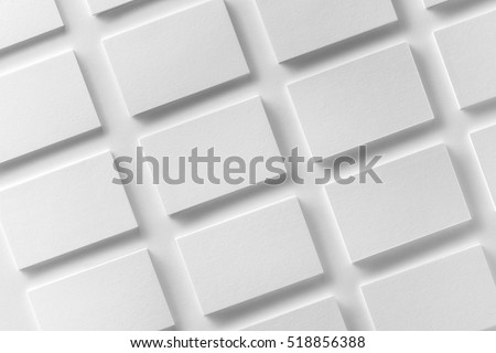Mockup of horizontal business cards stacks arranged in rows at white textured paper background. Royalty-Free Stock Photo #518856388