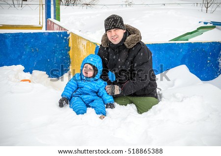 happy father and son having fun under winter snow.