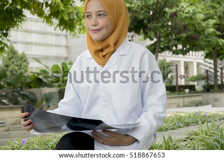 Young female doctor looking at the x-ray picture of lungs.