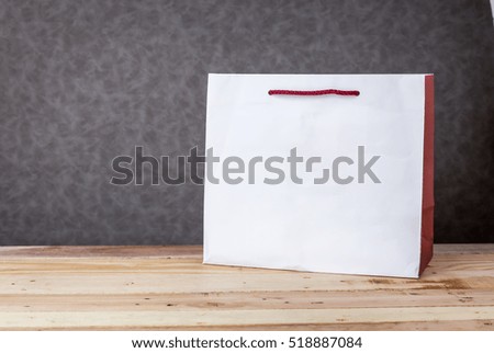 white paper bags with free cppyspace for your creativity ideas texts on wooden floor and grey background