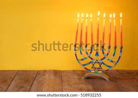 Image of jewish holiday Hanukkah background with menorah (traditional candelabra) and burning candles

