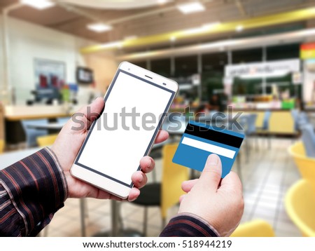 Hand Hold Smart phone with Credit Card over blurred of Shopping mall. blurry backgrounds