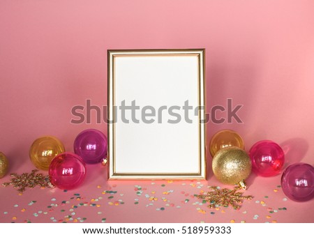 Gold picture frame with christmas ornaments. Mockup on pink background with confetti . Fashion decoration