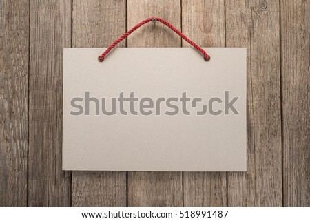 Signboard with rope on wooden background