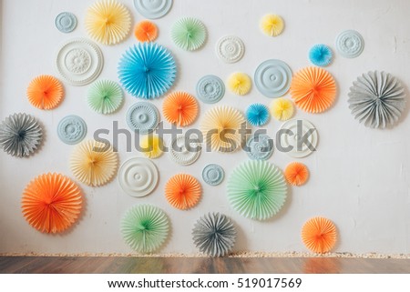 Wall decorated with colorful paper circles (petals) and plastic rosettes (ornaments with their own hands)