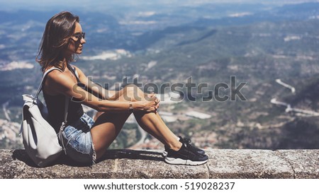 Hipster young girl with backpack and sunglasses looking on observation deck and planning travel plan. View tourist traveler on background panoramic view of the city mockup, summer in Barcelona 